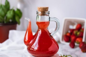 Glass bottle filled with strawberry syrup